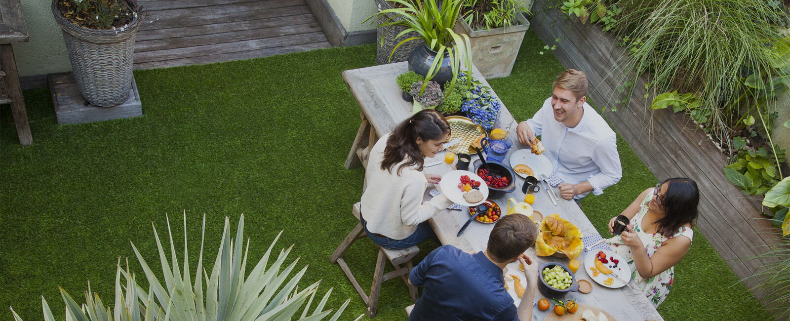 Rooftop terrace in grass, friends eating