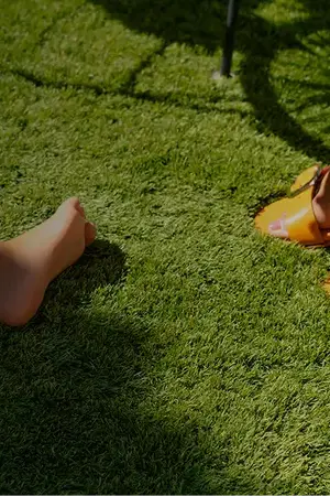  Feet of a woman and her daughter stepping on the new artificial turf installation for gardens by Turfgrass