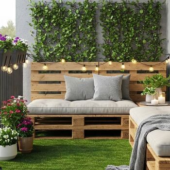 Terraza de un balcón decorada con césped artificial y palets.