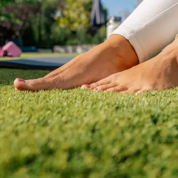 Pés sobre relva sintética para determinar a altura ideal da relva artificial em função da sua utilização.
