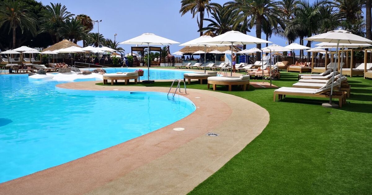 Zona de piscina de camping en la que se visualiza la utilización de césped artificial en zonas públicas.