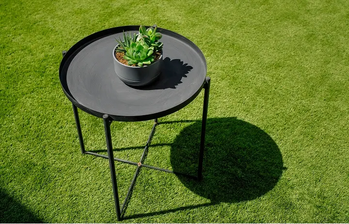 Outdoor table with plant pot in an artificial grass installation for terraces, balconies and attics by Turfgrass.