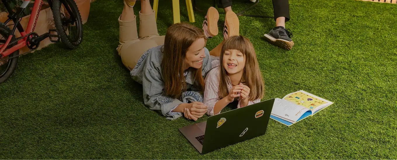 Mother and daughter lying on the floor on Turfgrass indoor artificial turf.