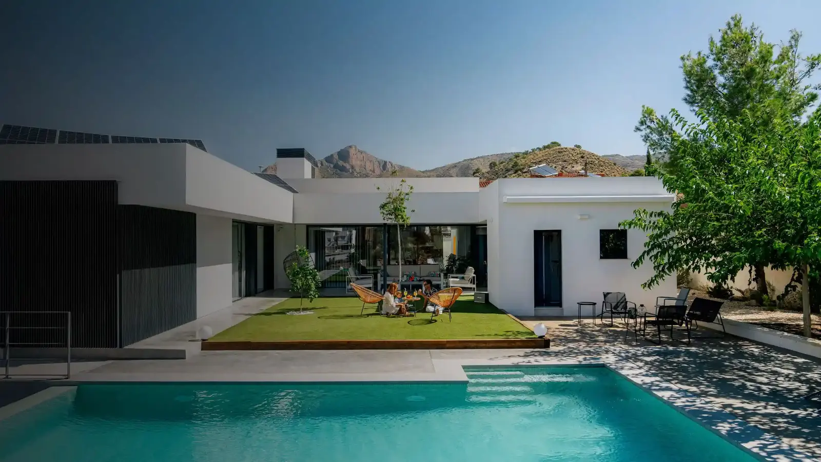 Familia disfrutando en su vivienda con césped artificial para piscinas.