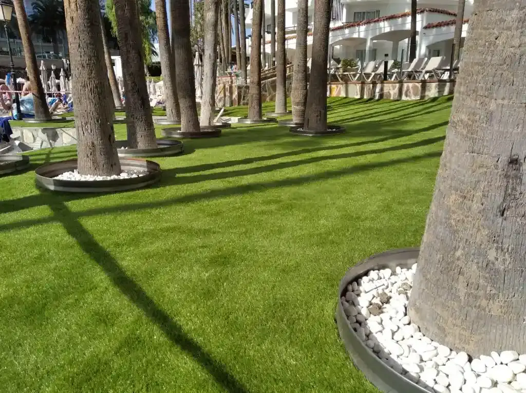Ground plan with synthetic turf for hotels next to trees to provide shade for the swimming pool.