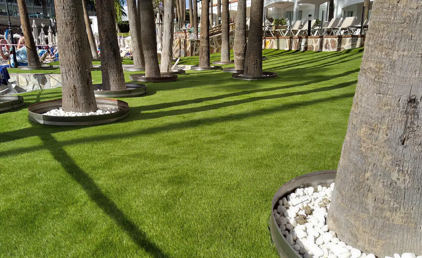 Ground plan with synthetic turf for hotels next to trees to provide shade for the swimming pool.