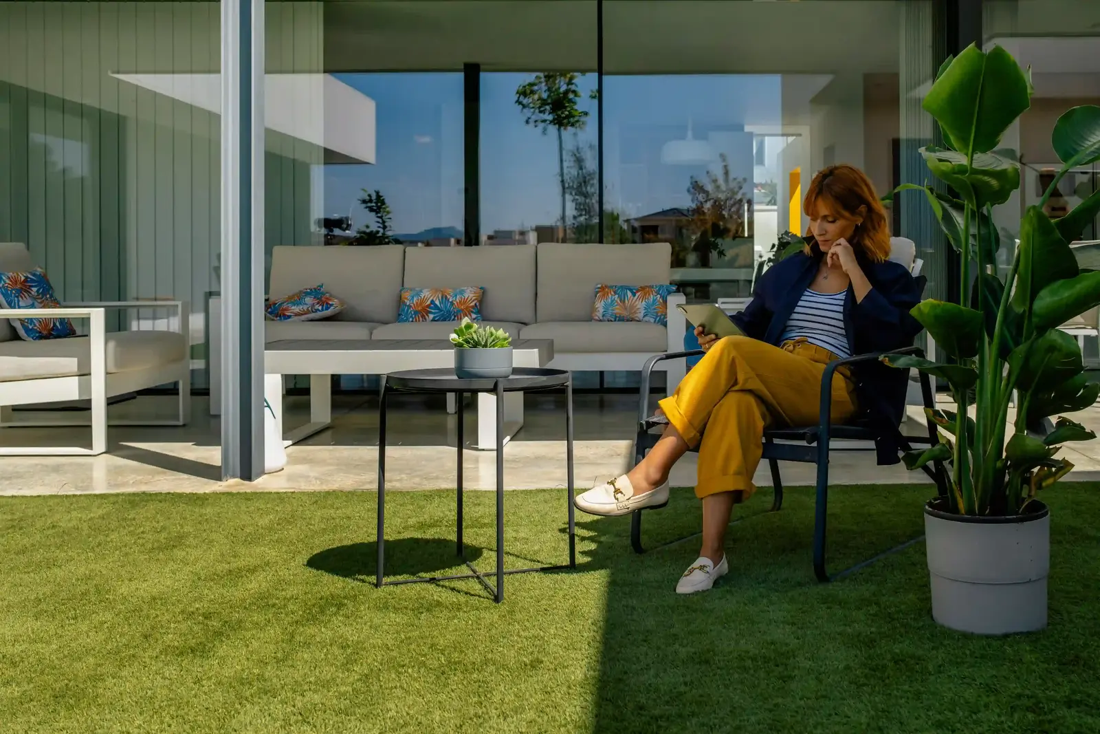 Woman enjoying herself on an indoor terrace with Turfgrass synthetic grass on the floor.